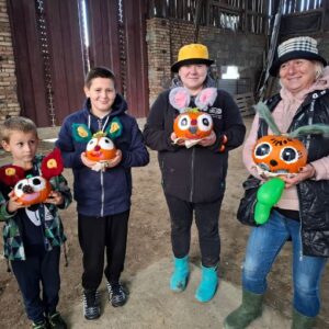 Uśmiechnięci uczestnicy z gotowymi dyniowymi lampionami w bieszczadzkim plenerze