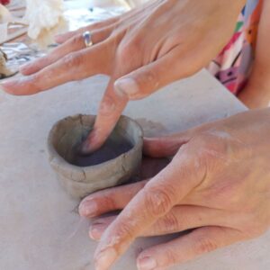 Młoda artystka precyzyjnie formująca glinianą miseczkę podczas zajęć