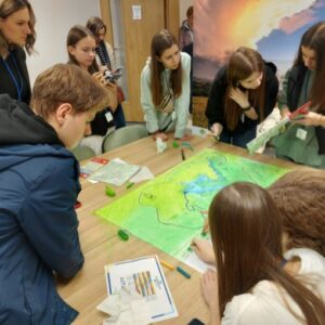 Zespół pracujący nad wspólnym projektem kartograficznym przy stole