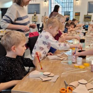 Dzieci malujace drewniane elementy dekoracyjne podczas zajęć plastycznych